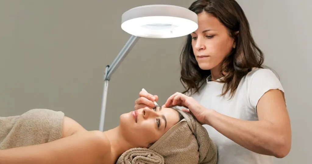 Carreira na Estética - Esteticista corrigindo as sobrancelhas do cliente