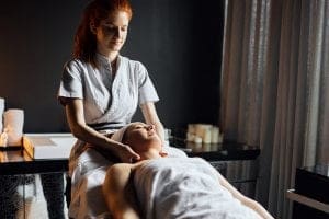 mulher massoterapeuta aplicando massagem em outra mulher - técnico em massoterapia
