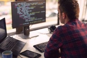 Jovem programador na frente do computador - melhores Cursos Técnicos para quem gosta de Tecnologia