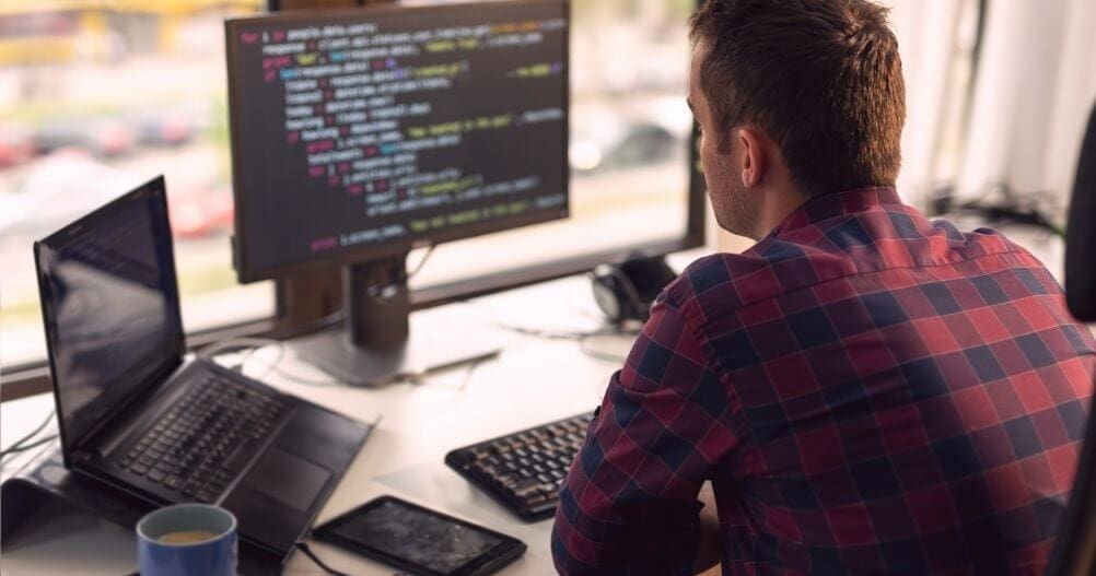 Jovem programador na frente do computador - melhores Cursos Técnicos para quem gosta de Tecnologia