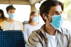 Jovem de mascara no ônibus indo ao trabalho - A pandemia aumentou a procura de Cursos Técnicos