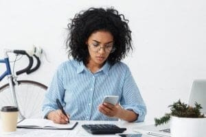 Estudante em escritório realizando contas - Mensalidade de Design de Interiores