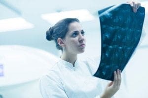 Técnico em radiologia avaliando os exames em raio-x de paciente - qualificações do Técnico em Radiologia e a carreira nessa área