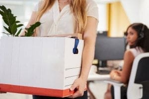 jovem mulher tirando seus pertences pessoais do escritório após demissão - Fui demitido, e agora?