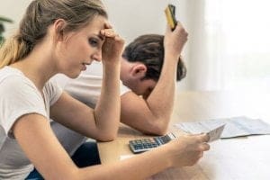 jovem casal com dificuldades financeiras - principais causas do desemprego e como evitá-las