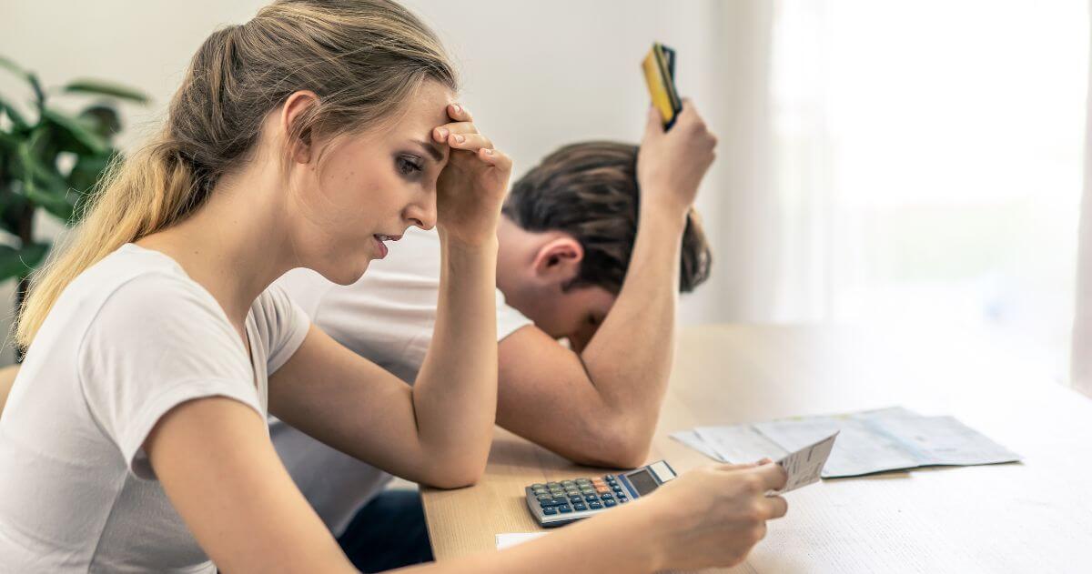 jovem casal com dificuldades financeiras - principais causas do desemprego e como evitá-las