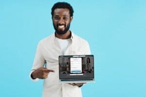 Homem negro apontando para laptop com página do LinkedIn - LinkedIn para conseguir um novo emprego