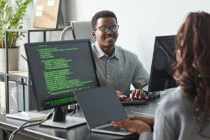 Jovens programadores no escritório da empresa - Vantagens para quem escolhe seguir carreira na área de Tecnologia da Informação