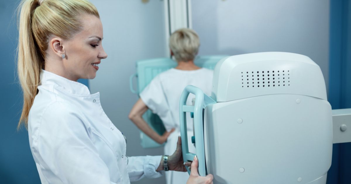 Carreira na Radiologia - Radiologista sorridente durante procedimento de raio-X no hospital