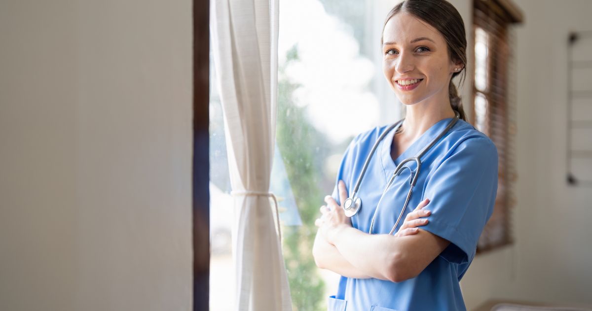 Auxiliar de Enfermagem: Retrato de uma simpática auxiliar de enfermagem vestindo uniforme azul e estetoscópio