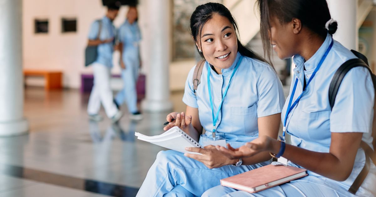 Especialização Técnica - Estudante asiática de enfermagem e sua amiga conversando enquanto estudavam no corredor da universidade médica.